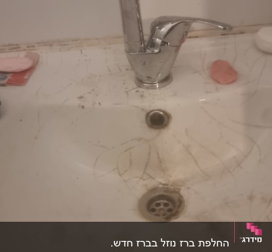 כיור וברז עם לכלוך וסימני שימוש